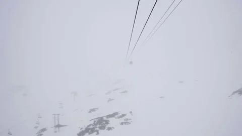 Cable car crossing deep snow covered valleys, advancing through thick Stock Footage 71006719
