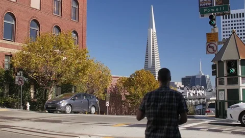 Cable car descending powell st. with transamerica pyramid  Stock Footage 83527791