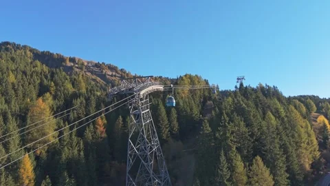 Cable car descends Dolomites mountain on sunny day, aerial view. Stock Footage 321550895