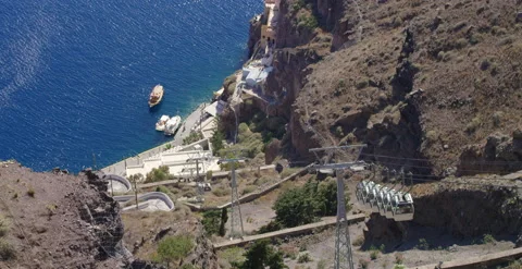 Cable car descends mountain side on bright afternoon, slow motion Stock Footage 202261504