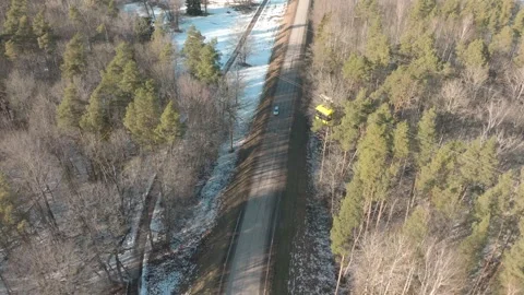 Cable car flying over a road surrounded by trees and snow in a rural area Video stock 333022878