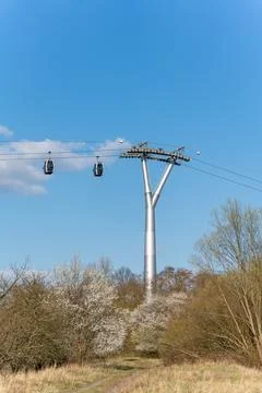 Cable car glides above blooming trees Stock Photos