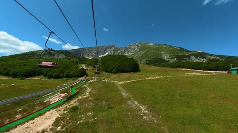 Cable car glides above lush green meadows. Savin Kuk peak, Montenegro Stock Footage 342981136