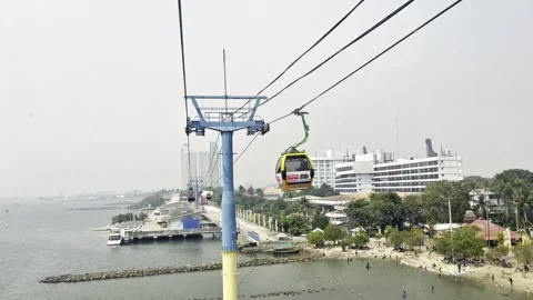 Cable car glides over calm water beside palm trees Stock Footage 340719403