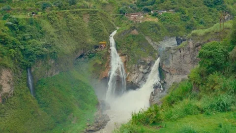 A cable car glides over a powerful waterfall in Ecuador, surrounded by lush Stock-Footage 345158522