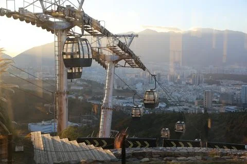 Cable car gondolas seen through cafe windows above a mountain city Stock Photos