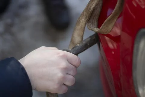 Cable for car. Guy hooks car for towing. Hand holds carabiner for screwing in Foto stock