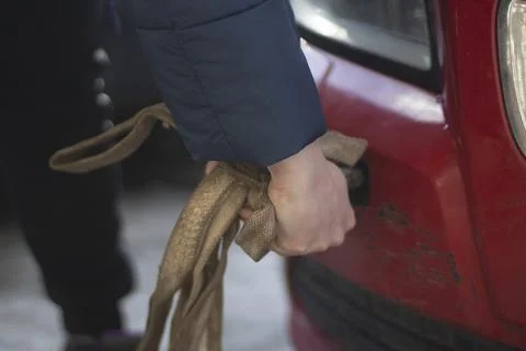 Cable for car. Guy hooks car for towing. Hand holds carabiner for screwing in Foto stock