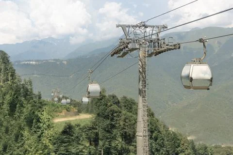 Cable car with mirror glasses on the background of summer green mountains and Stock Photos