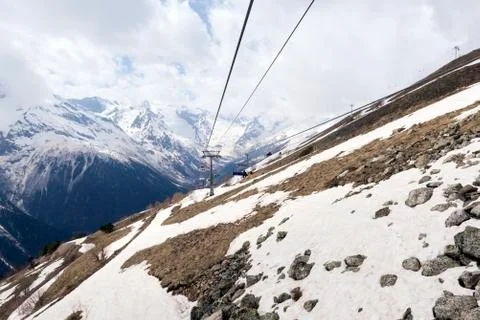 Cable car on the mountainside in spring, snow on the slope of the Caucasus mo Stock Photos