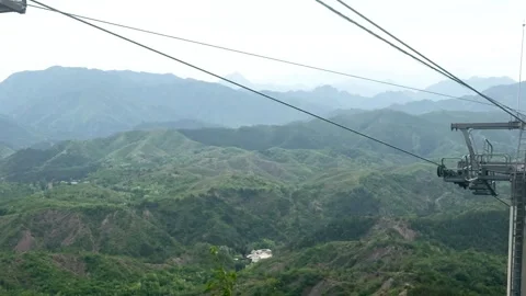 Cable car moving above lush green mountain forest Stockbeeldmateriaal 337650299