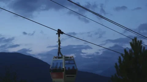 The cable car moving in mountains and colorful dark sky just right after sun set Video stock 153263043