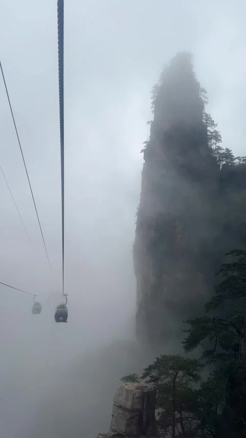 Cable car moving through thick fog over mountain peaks. 스톡 동영상 337649229