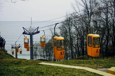 Cable car orange elevator move from top mountain down seashore, cloud autum.. Foto stock