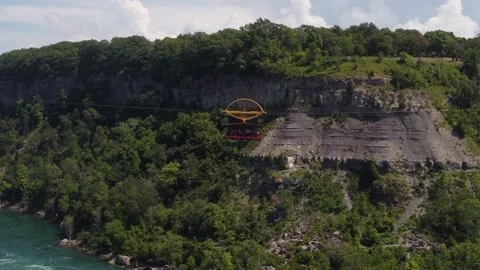 Cable car over large river with sheer cliff in the background, 4K Stock Footage 220899192