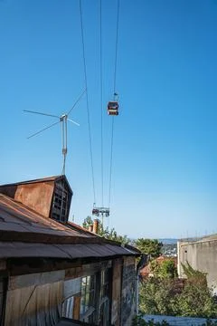 Cable car passing over old buildings and rooftops in Tbilisi, Georgia Stock Photos