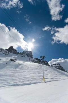 Cable car running alongside the skiing slope in the dolomites. Stock Photos