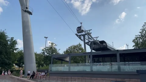Cable car station with clear sky and people sitting nearby, suitable for tr.. Stock Footage 314847539