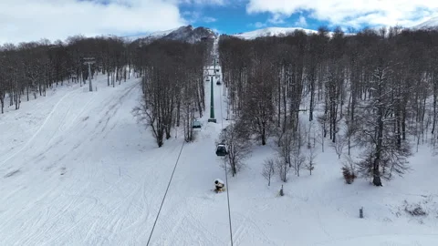 Cable car transporting tourists to the mountain peak over snowy ski trails Stock-Footage 327583458