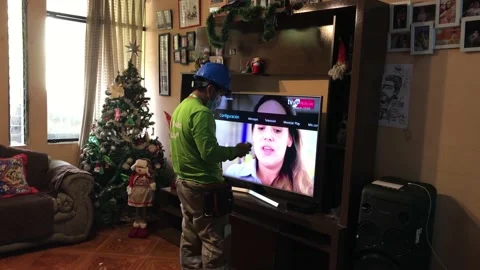 A cable channel technician installing a modem on the tv of a town house 库存影片 147458010
