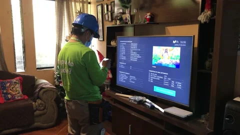 A cable channel technician repairing a modem on the tv 库存影片 147457290