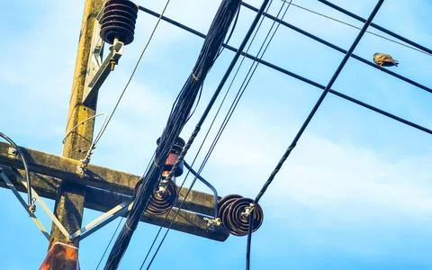 Cable clutter on a power pole in town blue sky. Stock Photos