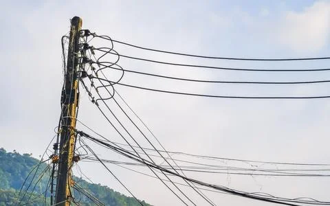 Cable clutter on a power pole in town city Thailand. Stock Photos