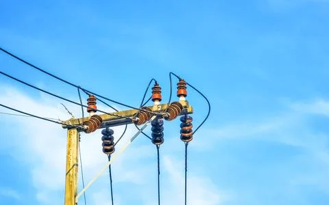 Cable clutter on a power pole in town blue sky. Stock Photos
