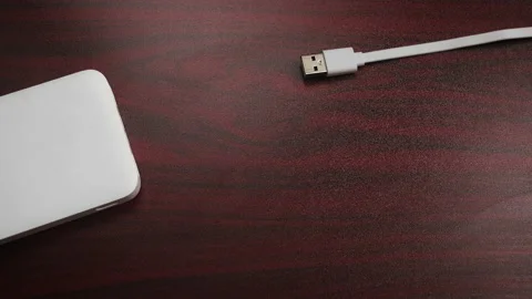 Cable connecting to the powerbank on the table surface Stock Footage 171539707