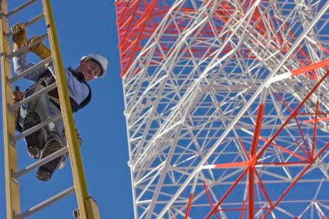 Cable lineman climbing down a ladder Stock Photos