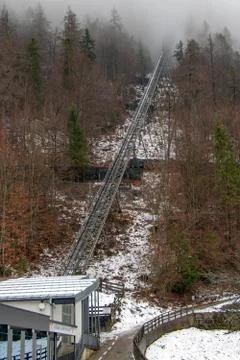 The cable railway ends in the clouds on the hill. Stock Photos