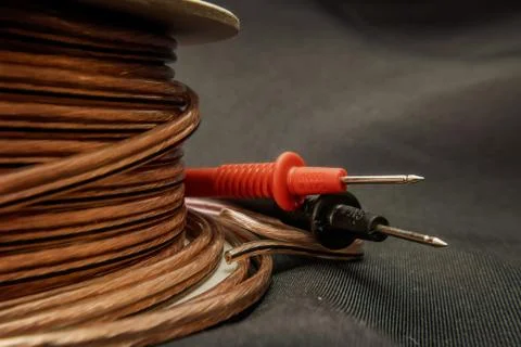 Cable roll isolated on dramatic background with volt meter tester Stock Photos