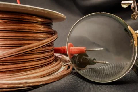 Cable roll isolated on grey background with magnifying glass Stock Photos