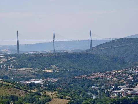 Cable stayed bridge crossing deep valley above patchwork farmland, forested.. Stock Photos