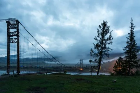 Cable-stayed bridge over a mountain river at dusk, Altai, Siberia Stock Photos