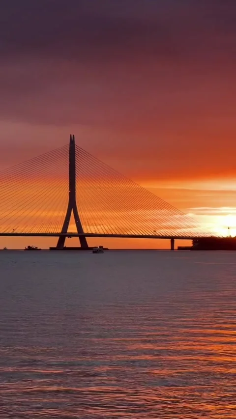Cable-Stayed Bridge Silhouette Over Water at Vibrant Orange Sunset Stock Footage 339725818