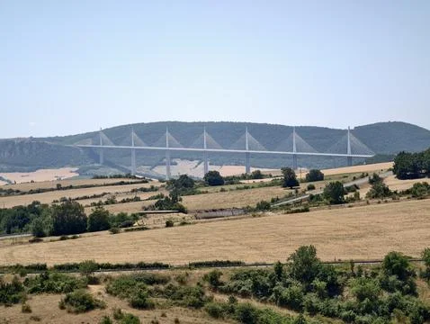 Cable stayed bridge spanning wide valley above harvested farmland and rolli.. Stock Photos