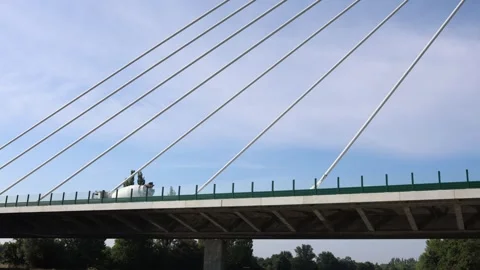 Cable-stayed bridge stretches over lush landscape with a cement truck crossing a Stock Footage 313843618