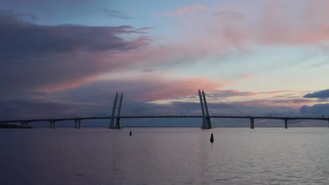 Cable-stayed bridge at sunset, car traffic on the highway over water, evening Video stock 224529400