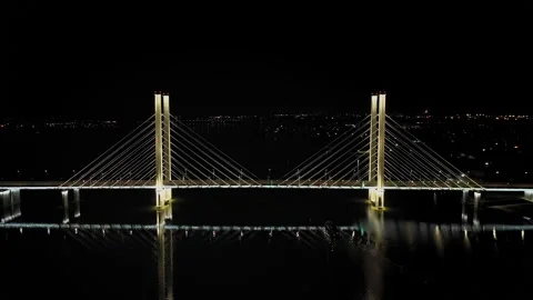 A cable-stayed highway bridge with tall concrete pylons illuminated by Stock Footage 257699856