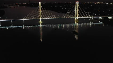 A cable-stayed highway bridge with tall concrete pylons illuminated by Stock Footage 257700377