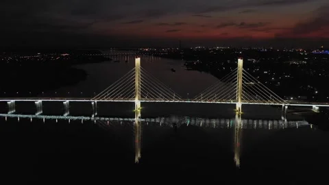 A cable-stayed highway bridge with tall concrete pylons illuminated by Stock Footage 257700439
