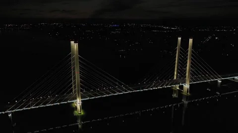 A cable-stayed highway bridge with tall concrete pylons illuminated by Stock Footage 257701062