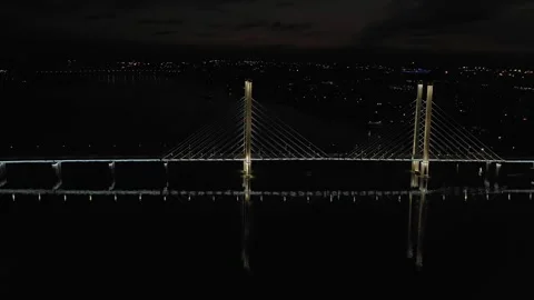 A cable-stayed highway bridge with tall concrete pylons illuminated by Stock Footage 257701427