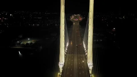 A cable-stayed highway bridge with tall concrete pylons illuminated by Stock Footage 257702083