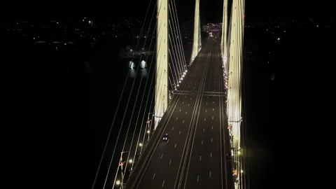 A cable-stayed highway bridge with tall concrete pylons illuminated by Stock Footage 257702302