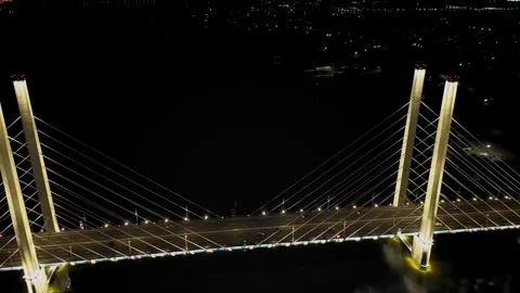 A cable-stayed highway bridge with tall concrete pylons illuminated by Stock Footage 257702445