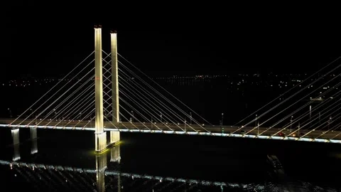 A cable-stayed highway bridge with tall concrete pylons illuminated by Stock Footage 257702539