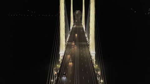 A cable-stayed highway bridge with tall concrete pylons illuminated by Stock Footage 257702629