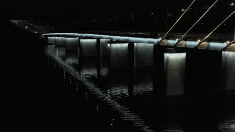 A cable-stayed highway bridge with tall concrete pylons illuminated by Stock Footage 257765148